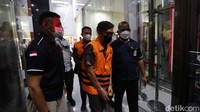 Prasetio Nugroho dan Redhy Novarisza keluar gedung KPK dengan mengenakan rompi tahanan. Tangannya juga diborgol.