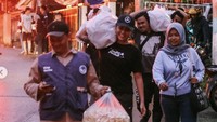 Bekerja sama dengan tim relawan dan warga sekitar, Awkarin tampak bersemangat. Ia tak segan memanggul seplastik besar nasi bungkus di pundaknya.