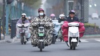 Banyak warga yang mengenakan pakaian tebal saat mengendarai motor untuk mengalau cuaca dingin.  
