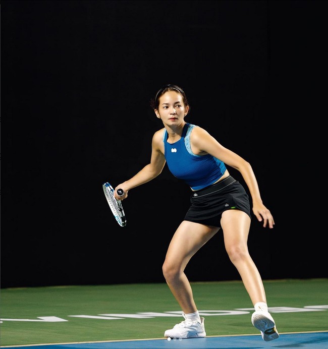 Enzy Storia memakai setelan crop top biru dan celana pendek hitam saat main tenis. Tampilannya makin sporty dengan sneakers putih. Foto: Instagram