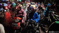 Banyak pengendara yang menunggu banjir surut di bahu jalan.