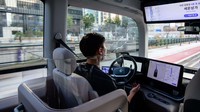 Manajer operasi penelitian dan pengembangan Kim Ki-suc memantau jalan saat dia duduk di kursi pengemudi tanpa menyentuh setir bus, saat bus tersebut mengemudi secara mandiri. Anthony Wallace/AFP/Getty Images