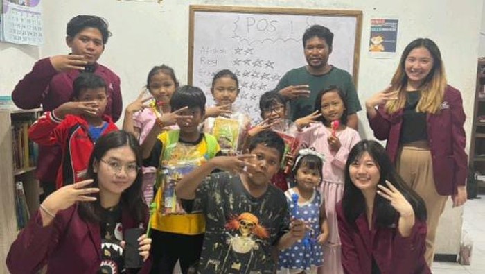 Mahasiswa Universita Ciputra bersama anak-anak peserta pembelajaran bahasa Inggris dan Kepala Sanggar Merah Merdeka, Heru