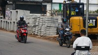 Sebuah alat berat tampak diparkirkan di trotoar Jl Cirendeu. 