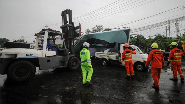 Sebuah papan reklame roboh di Jalan Raya Waru, kawasan Aloha Sidoarjo, Jawa Timur, Senin (28/11/2022). Angin kencang disertai hujan deras yang menerjang di wilayah setempat merobohkan sebuah papan reklame dan menimpa sebuah mobil, lima sepeda motor yang diparkir dan atap bangunan sentra kuliner. ANTARA FOTO/Umarul Faruq/wsj.