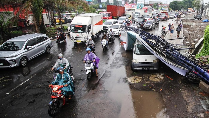 Sebuah papan reklame roboh di Jalan Raya Waru, kawasan Aloha Sidoarjo, Jawa Timur, Senin (28/11/2022). Angin kencang disertai hujan deras yang menerjang di wilayah setempat merobohkan sebuah papan reklame dan menimpa sebuah mobil, lima sepeda motor yang diparkir dan atap bangunan sentra kuliner. ANTARA FOTO/Umarul Faruq/wsj.