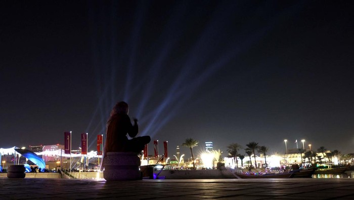 Soccer Football - FIFA World Cup Qatar 2022 - Doha, Qatar - November 27, 2022 A woman sits on The Corniche waterfront in Doha, Qatar. REUTERS/Lee Smith
