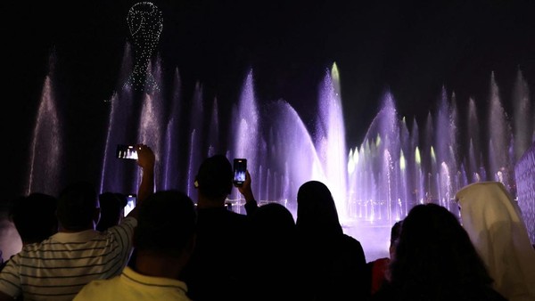 Orang-orang menonton pertunjukan kembang api dan cahaya di tepi pantai The Corniche di Doha, Qatar. 27 November 2022.
