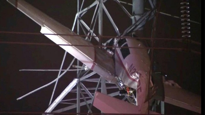 A small airplane hangs about 100 feet (33 metres) above the ground after crashing into an electricity tower in Gaithersburg, Maryland, U.S. November 27, 2022 in a still image from video. ABC affiliate WJLA via REUTERS