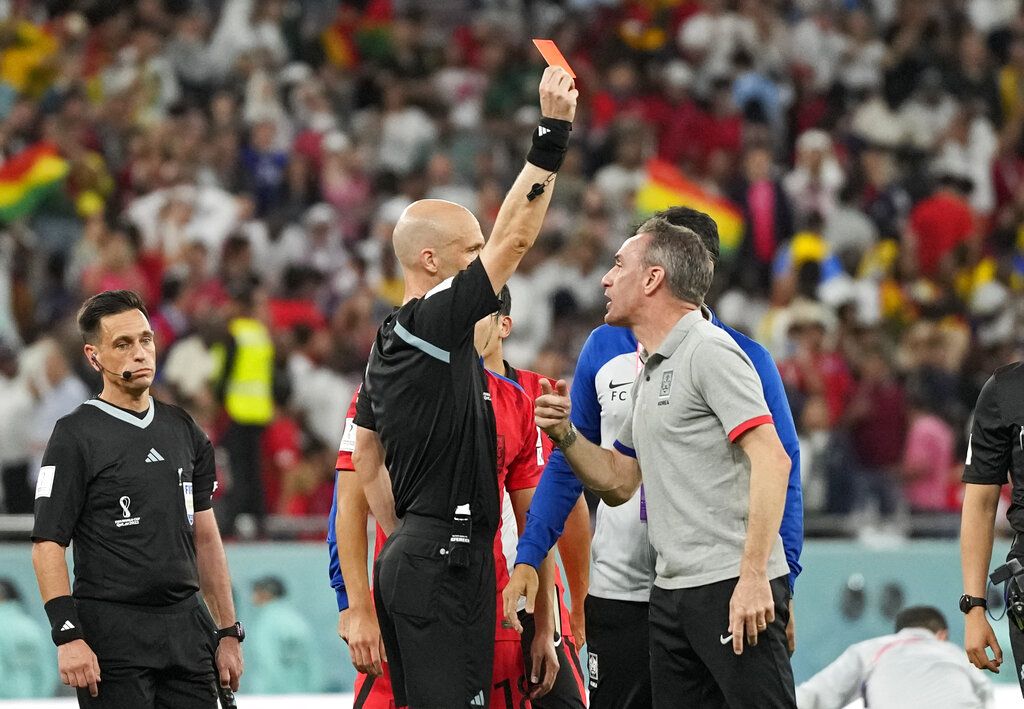 Referee Anthony Taylor shows the red card to South Korea's head coach Paulo Bento after the World Cup group H soccer match between South Korea and Ghana, at the Education City Stadium in Al Rayyan, Qatar, Monday, Nov. 28, 2022. (AP Photo/Lee Jin-man)