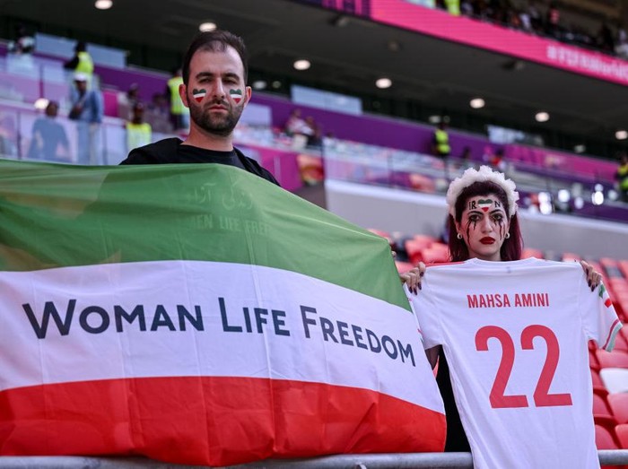 DOHA, QATAR - NOVEMBER 25: Fans of Iran protest with flags, banners with slogan Woman Life Freedom after death of Mahsa Amini for womens rights in Iran prior to the FIFA World Cup Qatar 2022 Group B match between Wales and IR Iran at Ahmad Bin Ali Stadium on November 25, 2022 in Doha, Qatar. (Photo by Harry Langer/DeFodi Images via Getty Images)