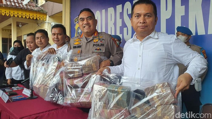 Polisi menunjukkan barang bukti uang tunai dan mobil yang disita dari pelaku RAM. (Raja Adil/detikSumut)