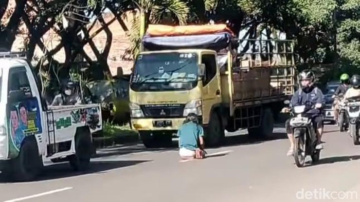 Tangkapan layar seorang wanita viral salat di tengah jalan di Kota Sukabumi