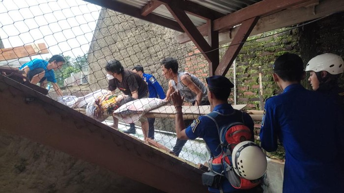 Evakuasi perempuan yang pingsan di atap rumah di Bandung.