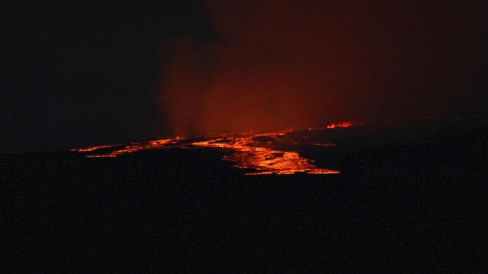 Lava pours out of the summit crater of Mauna Loa about 6:35 a.m. Monday, Nov. 28, 2022, as seen from Gilbert Kahele Recreation Area on Maunakea, Hawaii. Mauna Loa, the world’s largest active volcano, began spewing ash and debris from its summit, prompting civil defense officials to warn residents on Monday to prepare in case the eruption causes lava to flow toward communities. (Chelsea Jensen/West Hawaii Today via AP)
