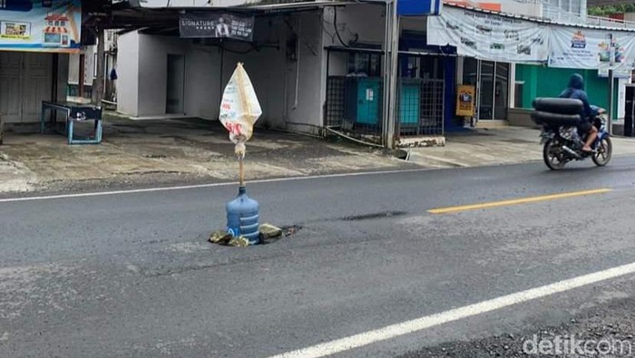 Jalan berlubang di Pangandaran dipasangi galon.