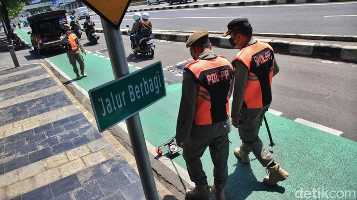 Petugas Satpol PP melakukan pada jalur sepeda di kawasan Semanggi. Aksi tersebut dilakukan untuk memastikan jalur sepeda aman dari ranjau paku dan serpihan benda tajam.