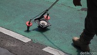 Dalam operasi tersebut, petugas Satpol PP berjalan di sepanjang jalur sepeda dengan membawa alat yang dapat mendeteksi benda-benda asing yang ada di jalan.