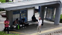 Sejumlah karyawan sedang menunggu kendaraan umum usai bekerja di perkantoran kawasan Sudirman, Jakarta. 