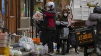 Seorang kurir mengambil bahan makanan pesanan online yang sudah disiapkan di luar supermarket.