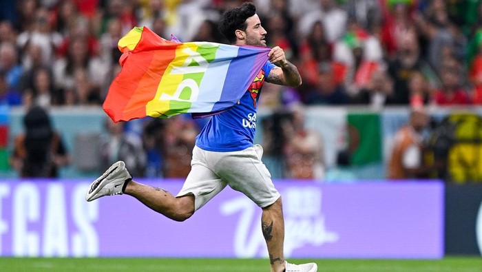 LUSAIL CITY, QATAR - NOVEMBER 28: A pitch invader wearing a shirt reading 