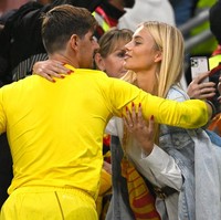 Kiper Belgia Thibaut Courtois terpotret memeluk dan hendak mencium istrinya Mishel Gerzig. Kemesraan itu terjadi usai pertandingan Belgia vs Kanada di Stadion Ahmad Bin Ali, Qatar, 23 November 2022. Foto: Getty Images