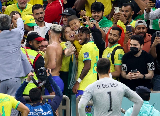 Pemain gelandang Brazil  Frederico Rodrigues de Paula atau lebih dikenal dengan nama Fred merayakan kemenangan timnya bersama sang istri Monique Salum dan anak mereka. Dalam pertandingan melawan Serbia, Brazil menang dengan skor 2 - 0. Foto: Getty Images