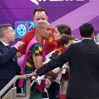 Joao Mario, pemain Portugal menemui istrinya Catia Almeida dan anaknya yang berada di bangku penonton Piala Dunia Qatar 2022. Mario tampak hendak mencium sang istri usai bertanding melawan Uruguay. Foto: Getty Images