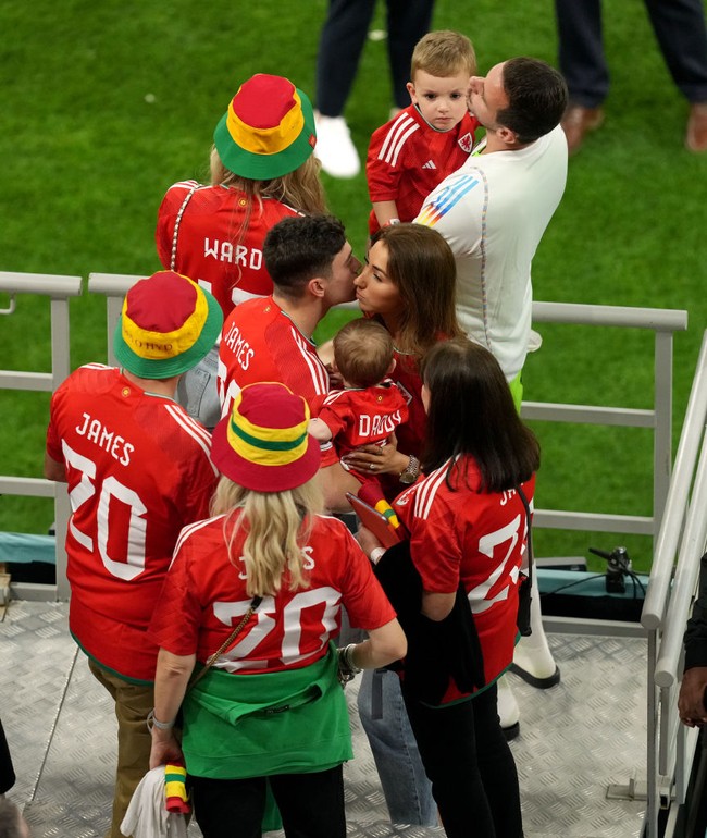 Pemain sepakbola dari tim Wales, Daniel James menemui pacar dan keluarganya yang terbang ke Qatar untuk menontonnya bertanding di Piala Dunia 2022. Daniel tampak mencium sang kekasih, Ria Hughes dan memeluk putranya, Layke, usai pertandingan Grup B PIala Dunia FIFA 2022. Foto: Getty Images