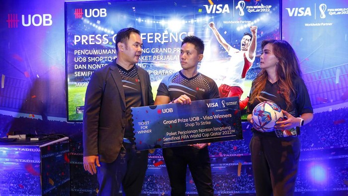 Beruntung! 2 Orang Ini Dapat Tiket Nonton Langsung Piala Dunia 2022 Executive Director, Cards and Payment Head UOB Indonesia Dewi Tuegeh (kanan) dan Head of Strategy Visa Indonesia Handikin Setiawan (kiri) mengumumkan Michael Sundjojo (tengah) sebagai salah satu pemenang grand prize Shop to Strike saat Press Conference di Jakarta, Rabu (30/11/2022).
