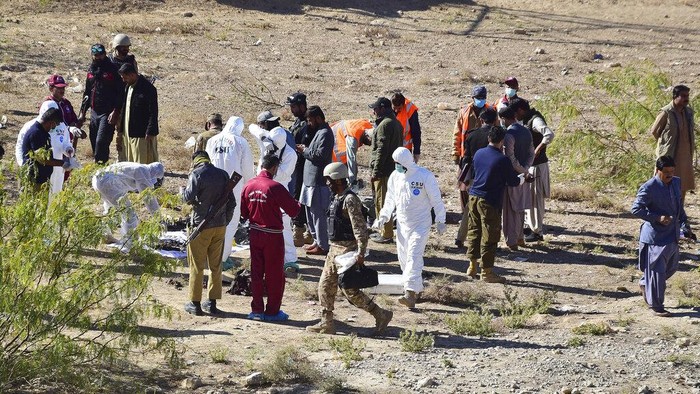 Pakistani security officials inspect at damaged truck at the site of suicide bombing on the outskirts of Quetta, Pakistan, Wednesday, Nov. 30, 2022. A suicide bomber blew himself up near a truck carrying police officers on their way to protect polio workers outside Quetta, wounding more than 20 others, mostly policemen, officials said. (AP Photo/Arshad Butt)