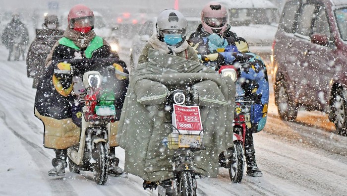 YANTAI, CHINA - NOVEMBER 17, 2022 - People brave snow on a street in Yantai, Shandong province, China, Nov 30, 2022. (Photo credit should read CFOTO/Future Publishing via Getty Images)