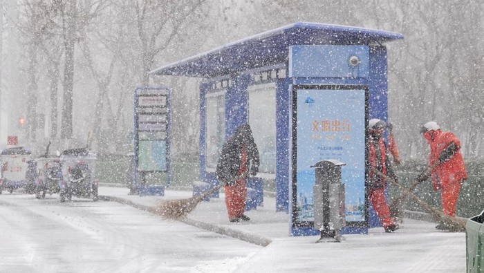 YANTAI, CHINA - NOVEMBER 17, 2022 - People brave snow on a street in Yantai, Shandong province, China, Nov 30, 2022. (Photo credit should read CFOTO/Future Publishing via Getty Images)