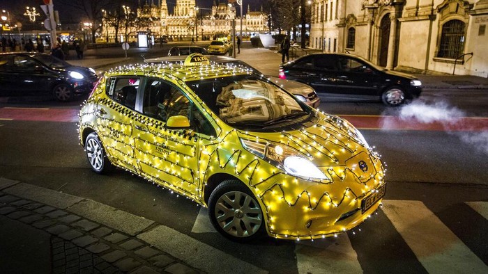 In this picture made available Tuesday, Dec. 6, 2016 shows a taxi decorated with Christmas lights cruising at Batthyany square in downtown Budapest, Hungary, Monday, Dec. 5, 2016. The festive taxi, along with its daily duty, delivers donations to the Tuzolto Utca Children's Clinic. The donations are collected by the taxi firm. (Zsolt Szigetvary/MTI via AP)