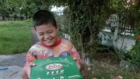 Seorang bocah tampak bahagia saat diberikan kardus pizza yang berukuran besar. Tetapi setelah dibuka ia hanya menemukan permen berbentuk pizza yang membuatnya mengernyitkan dahi. Foto: 1cak.com