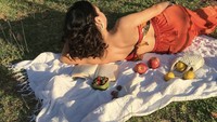 Piknik di taman, Arawinda melengkapi momennya dengan baca buku. Ada juga beragam buah segar sebagai santapan.