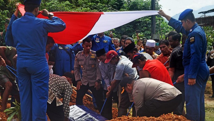 Sejumlah anggota Polri dibantu warga menurunkan peti jenazah korban helikopter jatuh Brigadir Anumerta M Lasminto untuk dikebumikan di Serang, Banten, Rabu (30/11/2022). Brigadir M Lasminto merupakan salahseorang korban helikopter milik Polri yang jatuh di laut Manggar, Bangka Belitung Selasa (29/11) lalu. ANTARA FOTO/Asep Fathulrahman/hp.