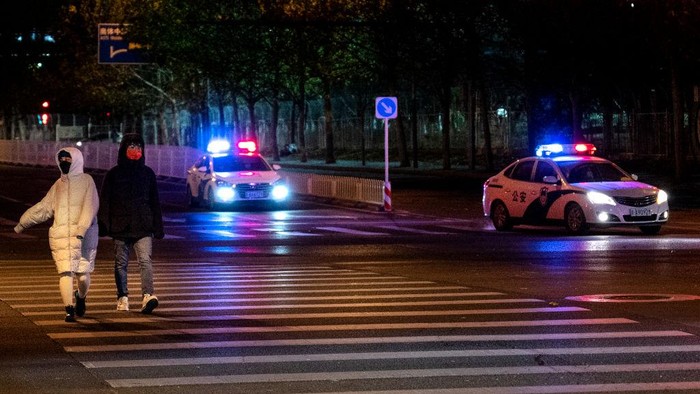 BEIJING, CHINA - NOVEMBER 29: Police cars drive through an intersection as they patrol in an area where there were rumours of a planned protest against the country's zero COVID measures on November 29, 2022 in Beijing, China. (Photo by Kevin Frayer/Getty Images)