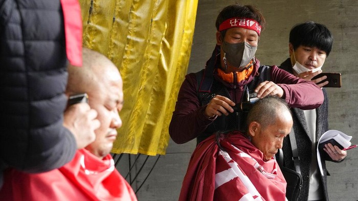 Ribuan Sopir Truk di Korea Selatan Mogok Kerja Members of the Cargo Truckers Solidarity union have their heads shaved during a rally against the government's return-to-work order on cement truckers in Uiwang, South Korea, Tuesday, Nov. 29, 2022. South Korea's government issued an order Tuesday for some of the thousands of truck drivers who have been on strike to return to work, insisting that their nationwide walkout over freight fare issues is hurting an already weak economy. (AP Photo/Ahn Young-joon)