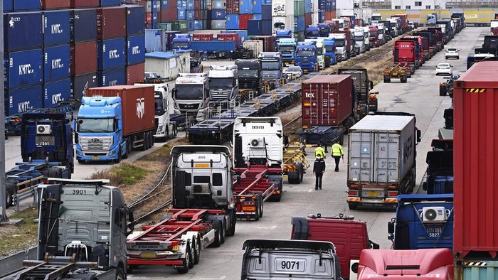 Ribuan Sopir Truk di Korea Selatan Mogok Kerja Trucks are parked next to containers at the Inland Container Depot in Uiwang, South Korea, Monday, Nov. 28, 2022. South Korea’s government issued an order Tuesday for some of the thousands of striking truck drivers to return to work, insisting that their nationwide walkout over freight fare issues is hurting an already weak economy. (Kim Jong-taek/Newsis via AP)