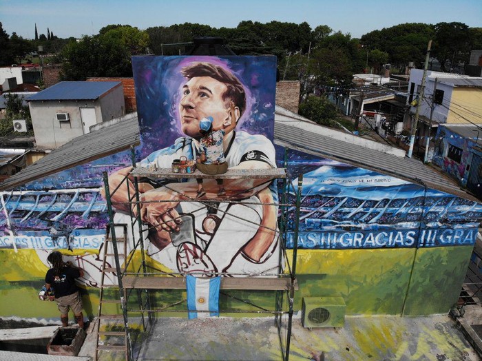 Artists Marlene Zuriaga and Lisandro Urteaga finish the details of a mural depicting Argentine football star Lionel Messi in his childhood home in Rosario, Argentina, on November 26, 2022. (Photo by MARCELO MANERA / AFP) (Photo by MARCELO MANERA/AFP via Getty Images)