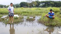Sejumlah anak asyik memancing ikan di kawasan TPU Tanah Kusir, Jakarta, Rabu (30/11/2022).