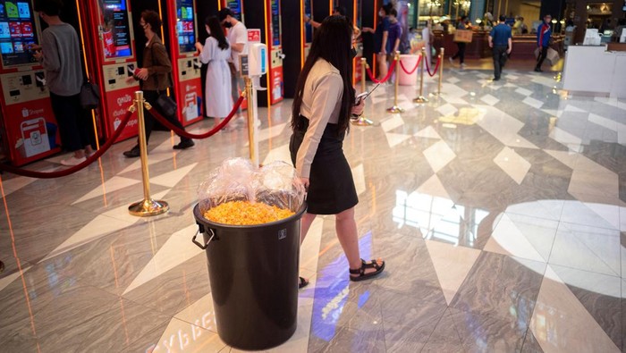 Serbuuu... Bioskop di Thailand Tawarkan Makan Popcorn Sepuasnya People carry steel vats, cardboard boxes and plastic storage containers as they queue during a campaign