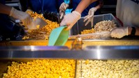 Staf bioskop menuangkan popcorn ke dalam ember plastik selama kampanye makan popcorn sepuasnya. Tidak hanya popcorn, pelanggan juga dapat mengisi ulang soda untuk membantu memuaskan pelanggan makan popcorn.
