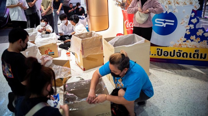 Serbuuu... Bioskop di Thailand Tawarkan Makan Popcorn Sepuasnya People carry steel vats, cardboard boxes and plastic storage containers as they queue during a campaign