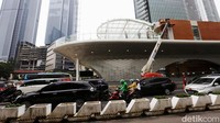 Pengendara melintas dengan latar belakang Halte Tosari yang dalam tahap revitalisasi di Jalan Jenderal Sudirman, Jakarta.