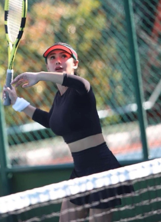 Dalam beberapa foto yang dibagikan secara sekaligus terlihat Yuni Shara mengenakan setelan olahraga berupa crop top lengan panjang dan rok mini berwarna hitam. Pakaian yang dikenakannya itu tampak memperlihatkan perut rata Yuni Shara dengan cukup jelas. Foto: Instagram/@yunishara36