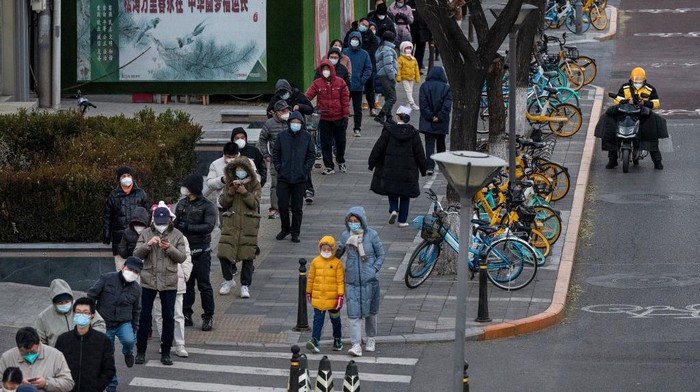BEIJING, CHINA - NOVEMBER 30: Residents wear masks to prevent the spread of COVID-19 as they wait in a long line for nucleic acid tests at a public testing site near an area where communities are in lockdown on November 30, 2022 in Beijing, China. In recent days, China has been recording its highest number of COVID-19 cases since the pandemic began, as authorities are sticking to their strict zero tolerance approach to containing the virus with lockdowns, mandatory testing, mask mandates, and quarantines as it struggles to contain outbreaks.In an effort to try to bring rising cases under control, the government last week closed most stores and restaurants for inside dining, switched  schools to online studies, and told people to work from home among other measures. (Photo by Kevin Frayer/Getty Images)