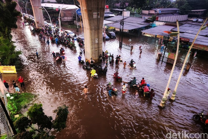 Banjir Juga Bikin Jalan Ciledug Kelelep Pemotor menuntun kendaraannya untuk menerobos banjir di Jalan Ciledug Raya, Kelurahan Petukangan, Kecamatan Pesanggrahan, Jakarta Selatan, Kamis (1/12/2022). Banjir akibat hujan deras. Foto diambil pukul 18.00 WIB.