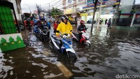 Pemotor menuntun kendaraannya untuk menerobos banjir di Jalan Ciledug Raya, Kelurahan Petukangan, Kecamatan Pesanggrahan, Jakarta Selatan, Kamis (1/12/2022).